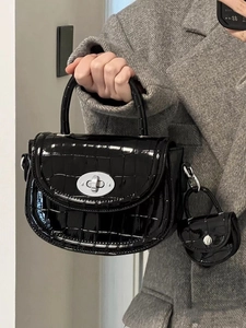 Détail du sac à main noir en cuir vernis embossé croco avec mini pochette
