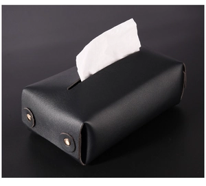 Detail of matte black PU leather tissue box showing fine lychee texture and bronze snap