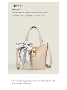 Detail of beige lychee leather bucket bag with gold twist lock and printed silk scarf