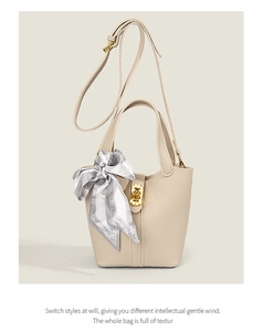 Close-up of beige lychee texture bucket bag with silk scarf and gold lock detail
