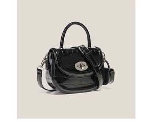 Détail du sac à main noir motif crocodile avec mini porte-monnaie et fermoir métallique