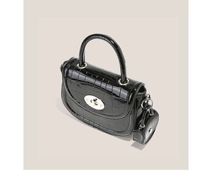 Détail du sac à main en cuir verni gaufré crocodile avec fermoir rotatif argenté