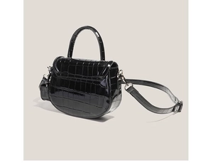 Vue détaillée du sac selle noir à motif crocodile avec finition brillante et ferrures argent