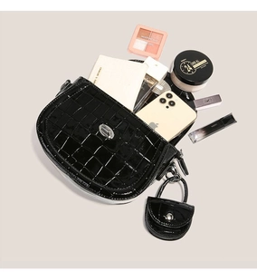 Vue détaillée du sac à main noir motif crocodile avec fermoir argenté et mini porte-monnaie