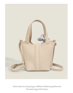 Detail of beige lychee leather bucket bag with silk scarf and adjustable strap