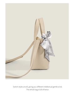 Detail of beige lychee grain leather tote bag featuring a decorative abstract silk scarf