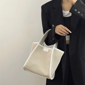 Minimalist canvas tote bag featuring premium white leather trim and sturdy top handles