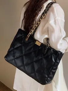 Rear view of a model wearing the large quilted tote bag with chain strap and turn-lock