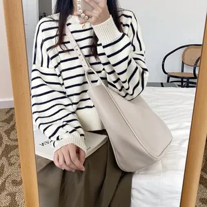 Mirror selfie showing the large beige tote bag worn over the shoulder for a modern look