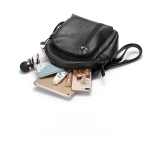 Detailed interior storage view of large black leather backpack with tablet and accessories