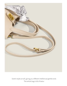 Detail of beige lychee leather tote bag featuring gold hardware and floral silk scarf