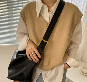 Minimalist black leather oversized shoulder bag with gold square buckle shown on model