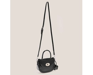 Détail du sac selle noir texture crocodile avec fermoir rotatif en métal argenté
