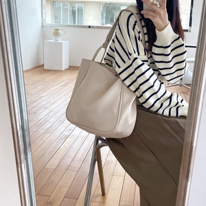 Mirror selfie showing the large beige leather tote bag capacity and styling on shoulder