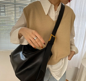 Detail of black large hobo bag with gold adjustable buckle on a shoulder strap