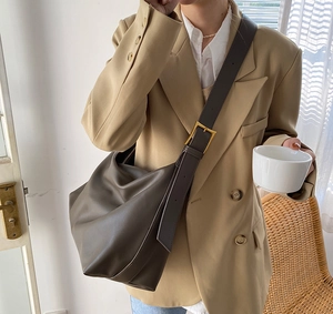 Detail of wide adjustable shoulder strap with golden buckle on minimalist tote bag