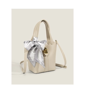 Elegant off-white lychee leather bucket bag with silk scarf and gold hardware details