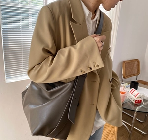 Close-up of hobo style soft leather shoulder bag in dark brown with wide strap detail