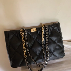 Classic black quilted tote bag with golden lock and dual-tone metal chain straps
