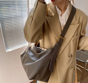 Detail of soft charcoal grey dumpling bag with wide strap and vintage gold buckle