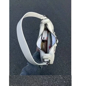 Vue intérieure montrant la capacité du sac à bandoulière blanc avec logo D argenté