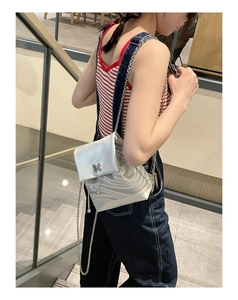 Mini sac à dos argenté Y2K avec boucle papillon et pompons en chaîne sur un mannequin