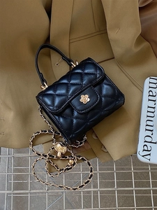Dettaglio mini borsa trapuntata nera con chiusura a camelia dorata e tracolla a catena