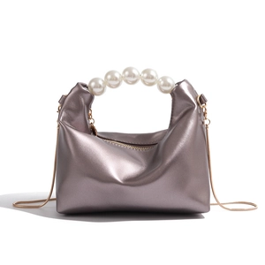 Silver mini dumpling pearl handle bag with gold chain strap on white background