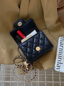 Dettaglio della capacità interna della mini borsa trapuntata nera per rossetto e trucco
