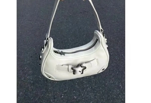 Détail d'un sac sous le bras blanc Y2K avec boucle étoile métallique sur l'asphalte
