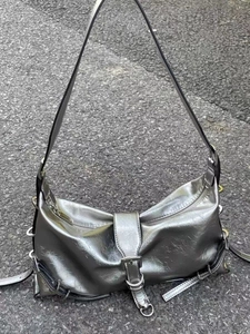 Detail of silver metallic shoulder bag showing crinkled texture and metal buckle closure