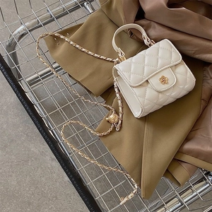 Dettaglio di una mini borsa bianca trapuntata con chiusura a camelia e catena dorata
