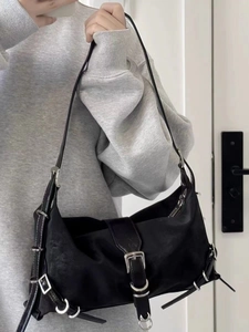 Detail of black nylon shoulder bag with silver metal buckles and adjustable strap