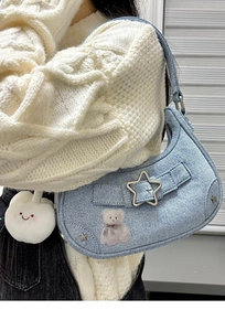 Détail du sac hobo en jean bleu clair avec étoiles en métal et breloque nuage