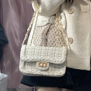 Detail of white tweed texture with gold metallic threads and elegant chain strap clasp