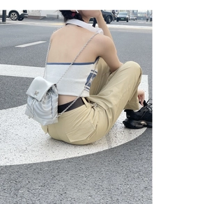 Détail du sac à dos argenté avec fermoir papillon et texture matelassée pour femme