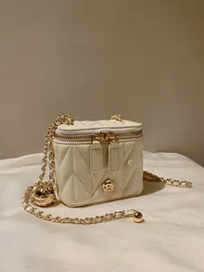 Detailed macro view of white quilted texture and gold floral metal buckle on the chain bag