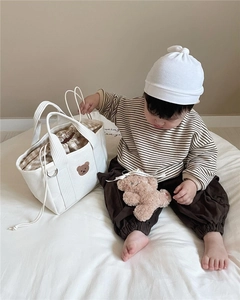Detail of canvas diaper bag featuring cute bear embroidery and checkered drawstring lining