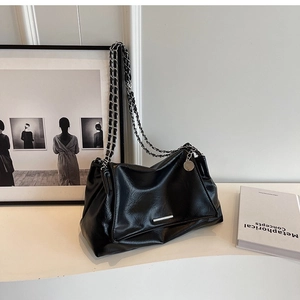 Detail of black soft leather tote with vintage texture and silver chain strap