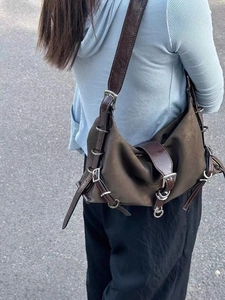 Detail view showing a retro brown hobo bag with multiple leather straps and metal buckles