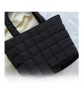 Close-up of black quilted nylon fabric texture and stitching on the tote bag