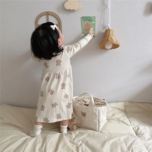 Detail of baby bear print canvas lunch bag and knit dress set in warm beige tones