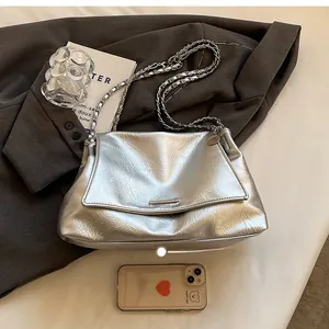 Detail of silver crinkled leather tote with metal chain strap and flap closure