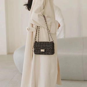 Elegant black houndstooth tweed chain bag with gold hardware and woven metal strap