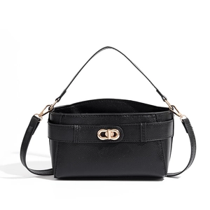 Close-up of black lychee grain leather bag featuring a polished gold twist lock closure