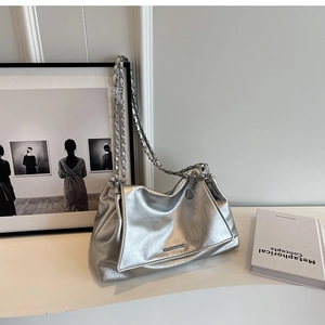 Detail of silver metallic tote bag featuring cracked leather texture and chain strap