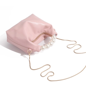 Detailed top view of soft pink mini dumpling bag with pearl handle and gold chain