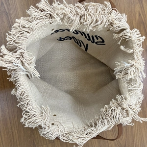 Top view of woven beach tote featuring Summer Vibes embroidery and fringe details