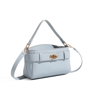 Close-up of glacier blue lychee texture leather bag with elegant golden rotary buckle