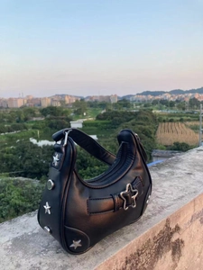 Détail du sac d'épaule en cuir PU noir avec boucle étoile et clous argentés
